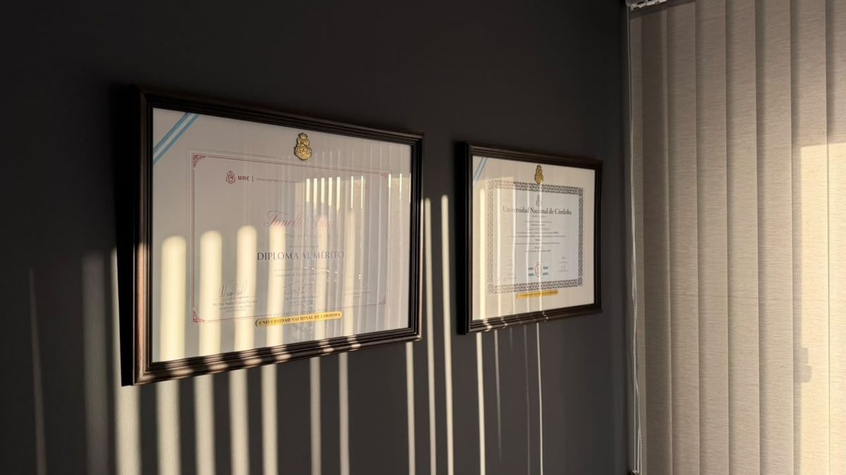 Diplomas de la Universidad Nacional de Córdoba enmarcados en la pared del estudio